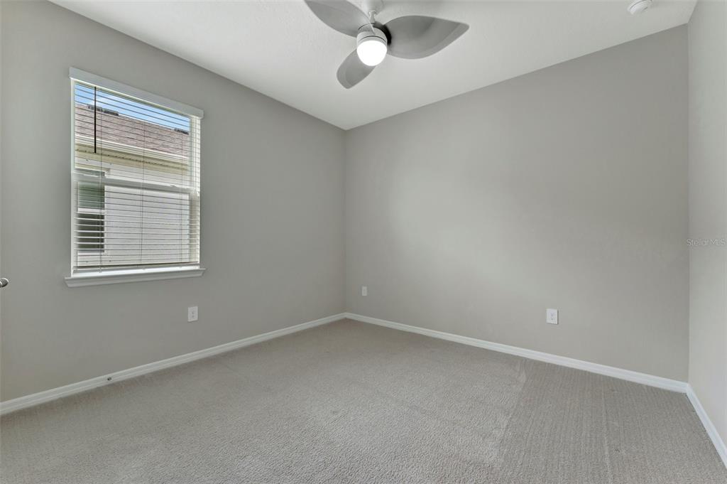 5210 Grove Mill Loop Lakewood Ranch, FL 34211 - Photo 27 of 48 an empty room with a window and a ceiling fan