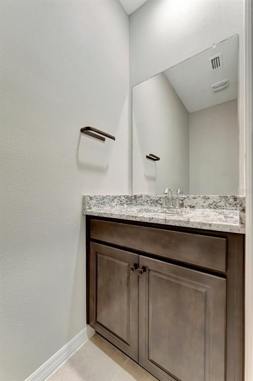 5210 Grove Mill Loop Lakewood Ranch, FL 34211 - Photo 34 of 48 a bathroom with a granite countertop sink and white cabinets