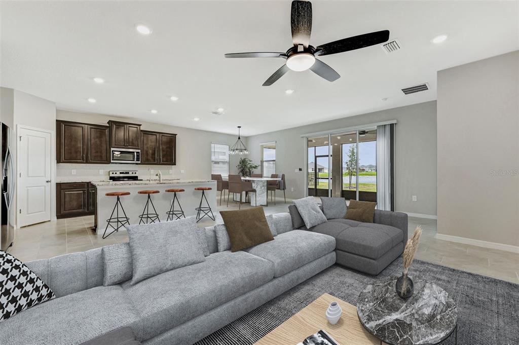 5210 Grove Mill Loop Lakewood Ranch, FL 34211 - Photo 36 of 48 a living room with furniture and a flat screen tv