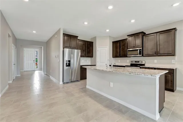 a kitchen with stainless steel appliances granite countertop a refrigerator and a stove top oven