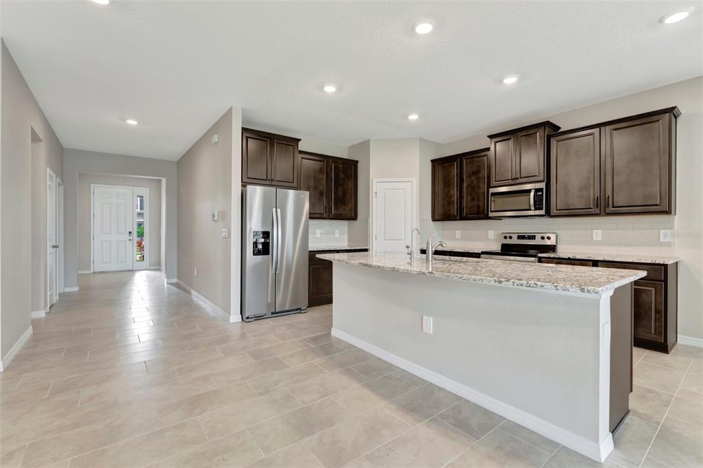 5210 Grove Mill Loop Lakewood Ranch, FL 34211 - Photo 5 of 48 a kitchen with stainless steel appliances granite countertop a refrigerator and a stove top oven