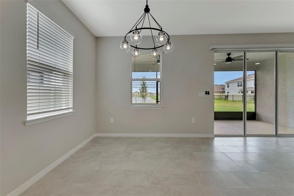 5210 Grove Mill Loop Lakewood Ranch, FL 34211 - Photo 9 of 48 en empty room with wooden floor and windows