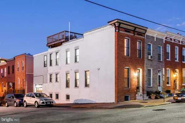a front view of a building with cars parked