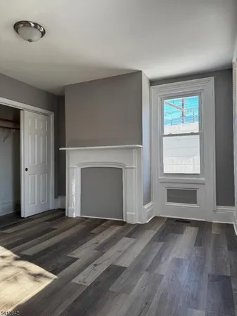 a view of empty room with wooden floor and fireplace