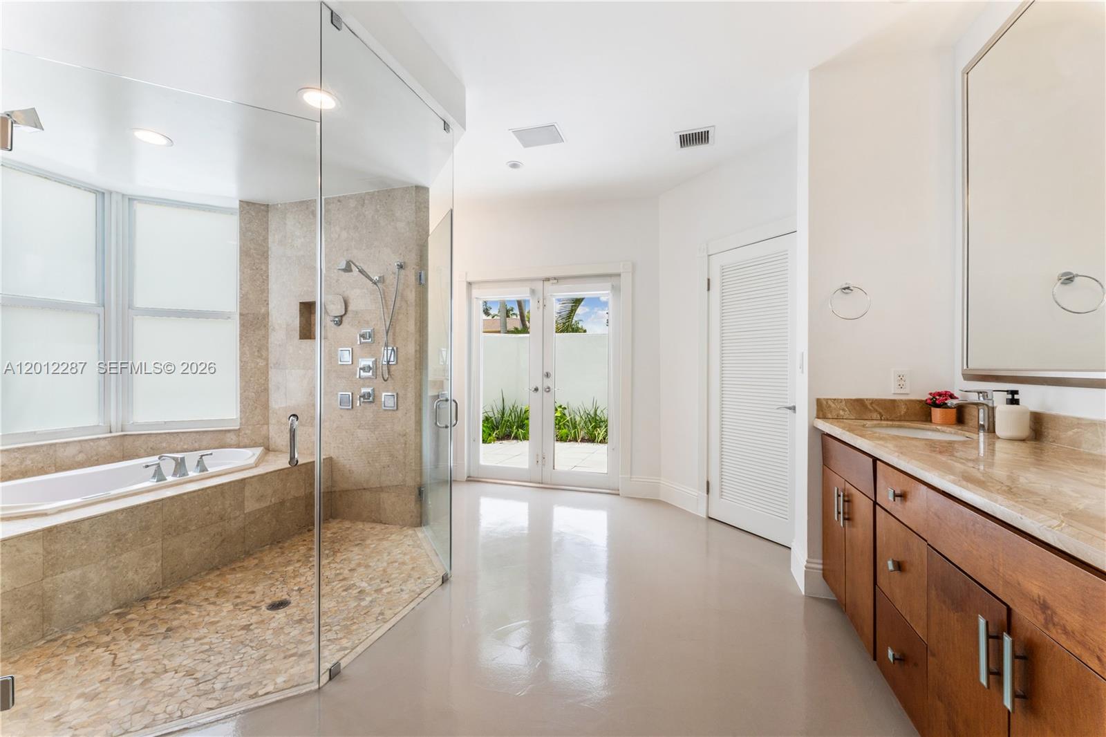 8763 Southwest 61st Place Pinecrest, FL 33156 - Photo 11 of 30 a spacious bathroom with a shower sink and mirror