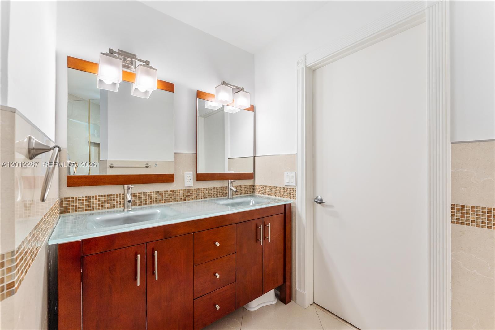 8763 Southwest 61st Place Pinecrest, FL 33156 - Photo 15 of 30 a bathroom with a sink and a mirror