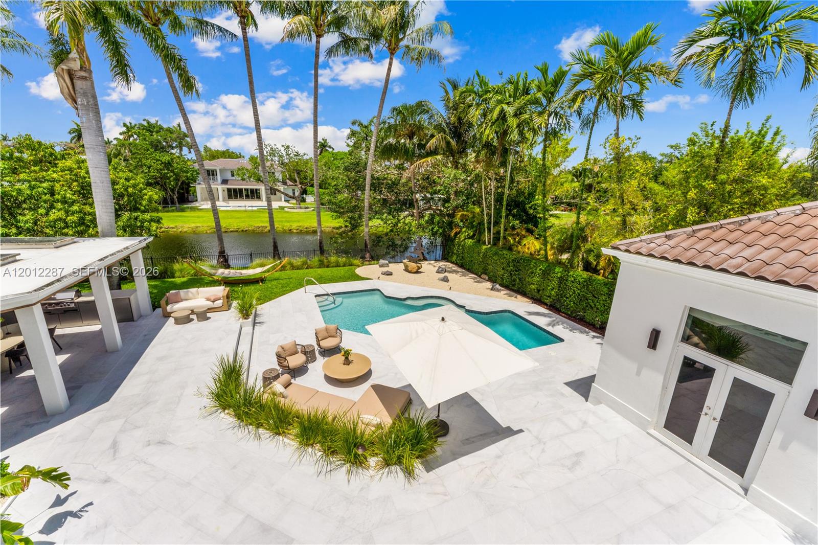 8763 Southwest 61st Place Pinecrest, FL 33156 - Photo 26 of 30 a view of a swimming pool with a patio