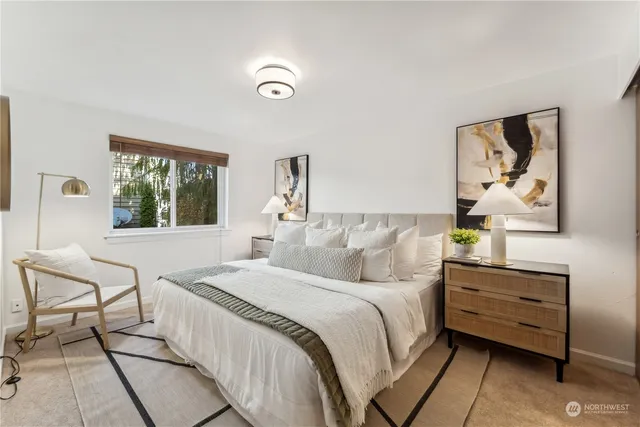 a bedroom with a bed and a painting on the wall