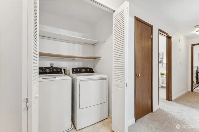 a view of washer and dryer with kitchen in the background