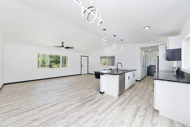 a kitchen with kitchen island a sink stove and wooden floor