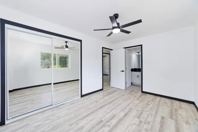 a bathroom with a granite countertop sink a toilet a mirror and shower