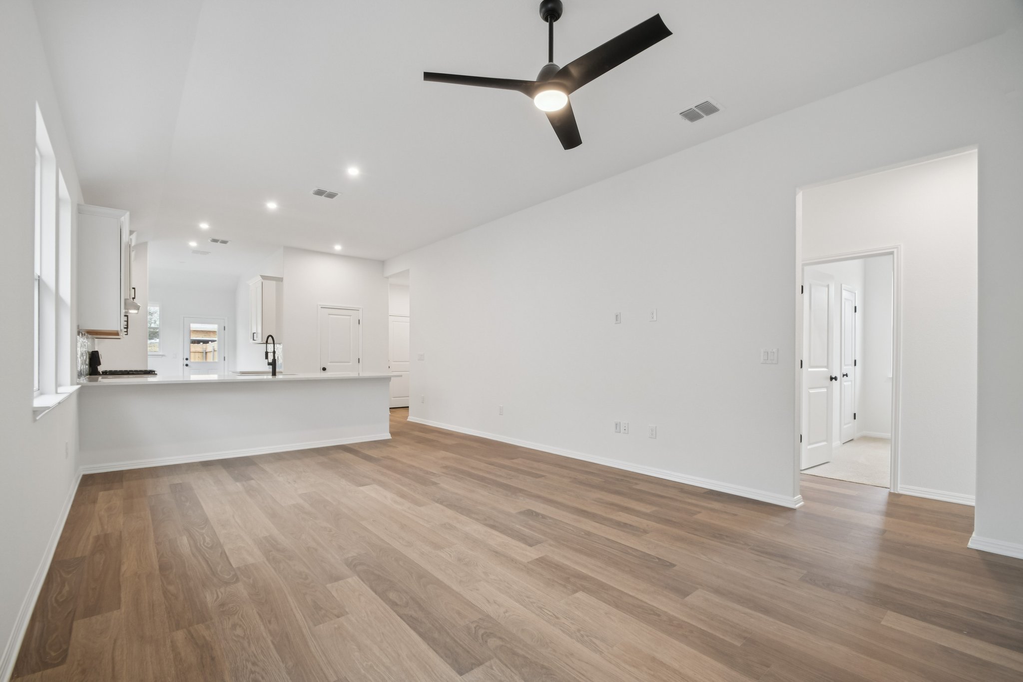 6385 Marsh Lane Buda, TX 78610 - Photo 6 of 35 a view of kitchen and empty room with wooden floor