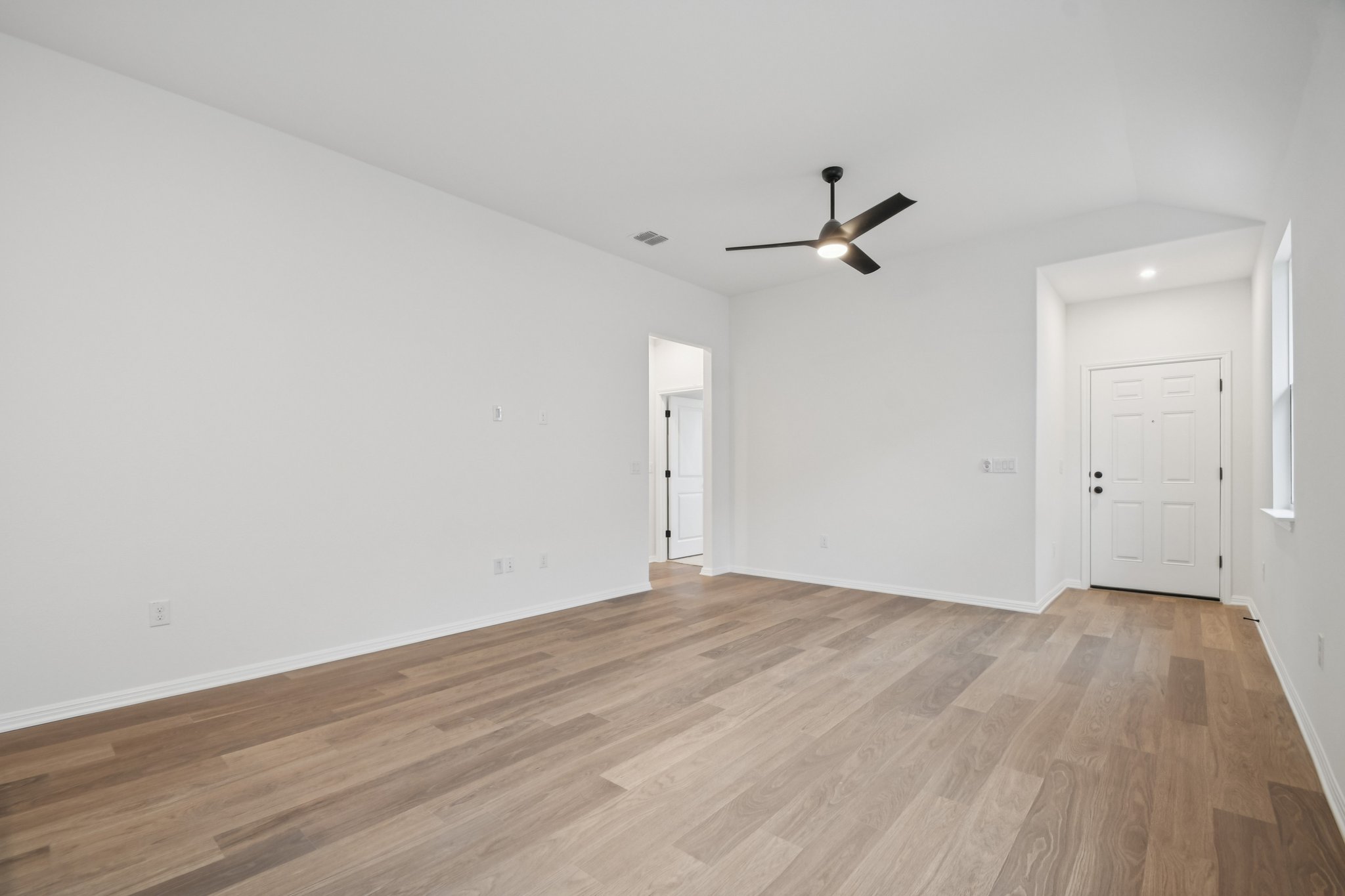 6385 Marsh Lane Buda, TX 78610 - Photo 7 of 35 an empty room with wooden floor ceiling fan and windows