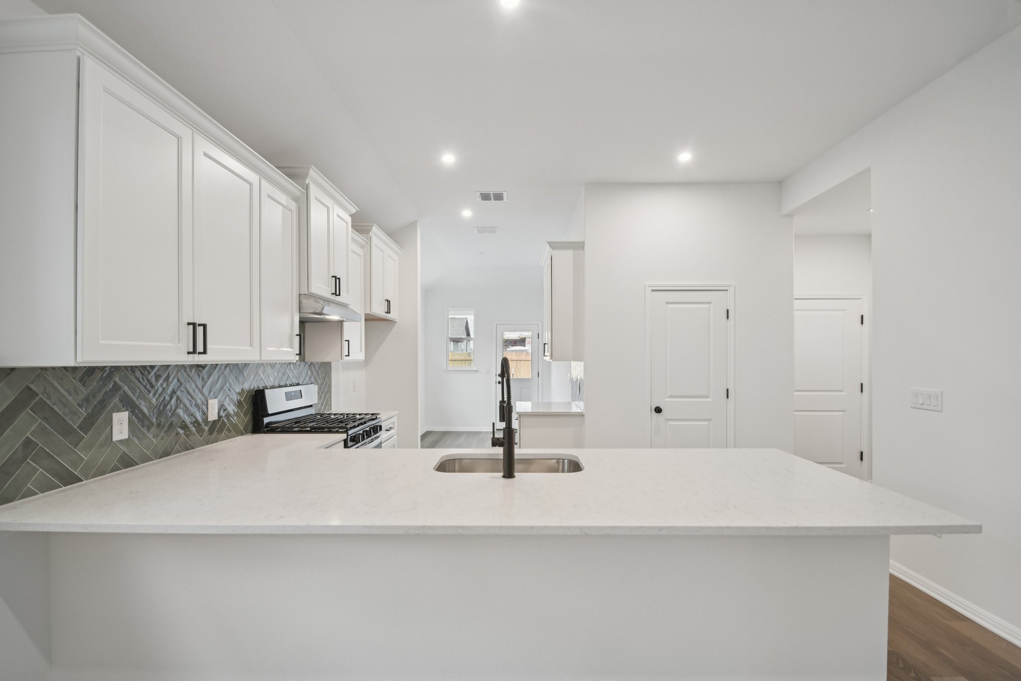 6385 Marsh Lane Buda, TX 78610 - Photo 8 of 35 a kitchen with kitchen island a sink a stove and a window