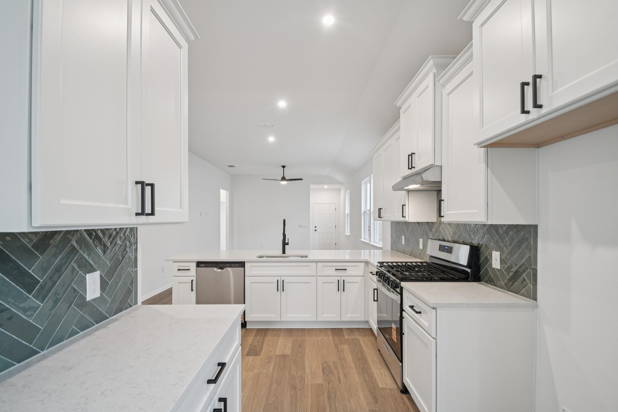 6385 Marsh Lane Buda, TX 78610 - Photo 10 of 35 a kitchen with white cabinets sink and stove