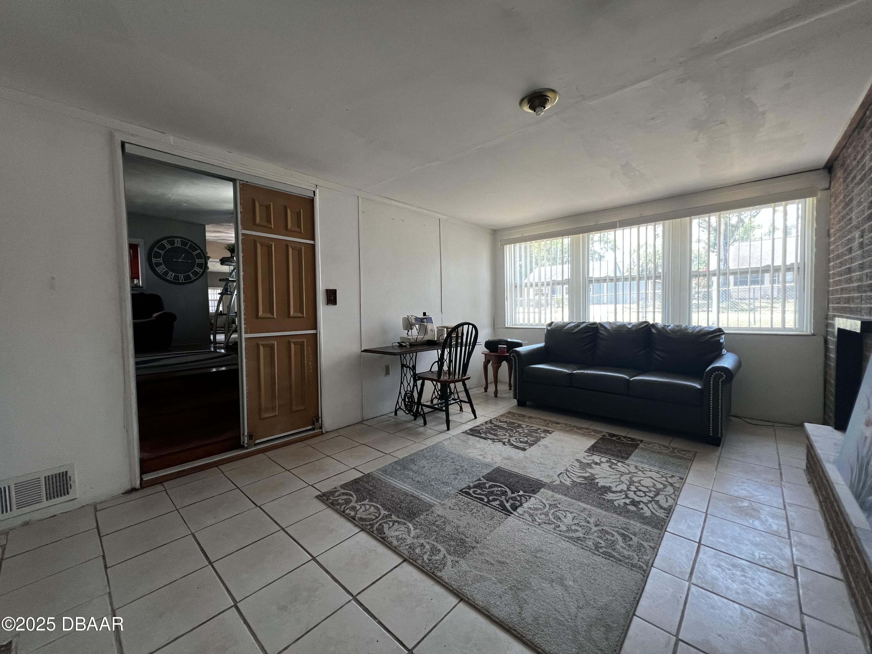 601 Berkshire Road Daytona Beach, FL 32114 - Photo 16 of 21 a living room with furniture and a refrigerator