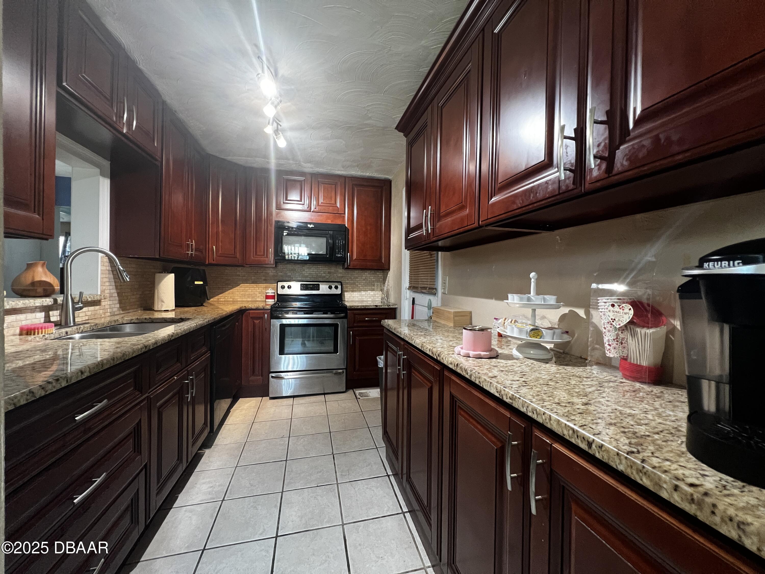 601 Berkshire Road Daytona Beach, FL 32114 - Photo 6 of 21 a kitchen with granite countertop stainless steel appliances and cabinets