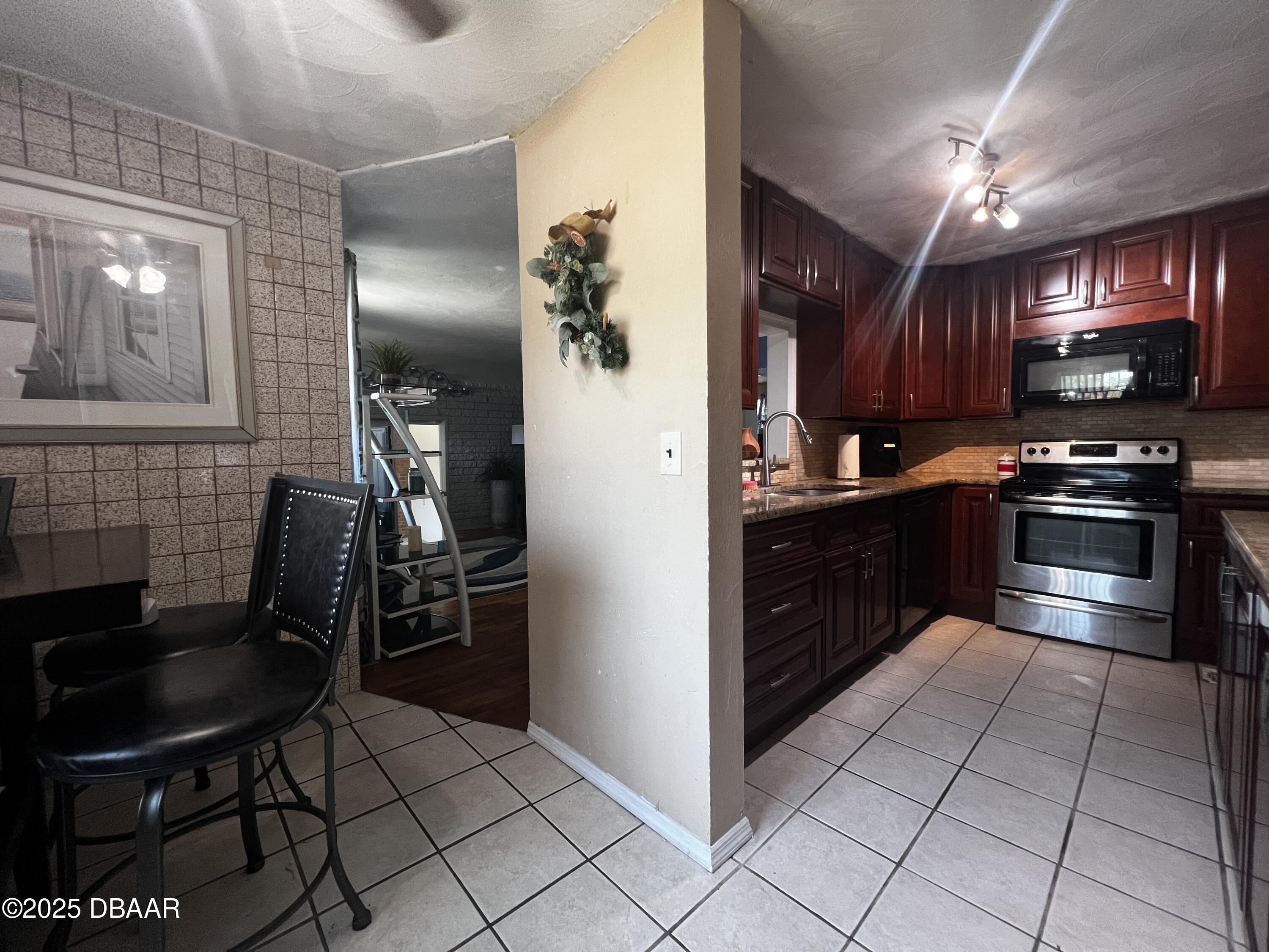 601 Berkshire Road Daytona Beach, FL 32114 - Photo 7 of 21 a kitchen with stainless steel appliances granite countertop a stove a sink and a refrigerator