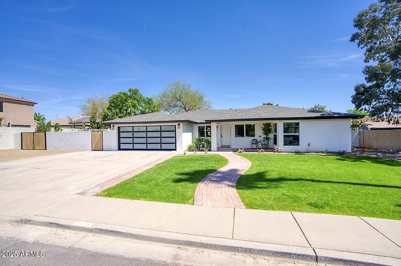 a front view of a house with a yard and trees