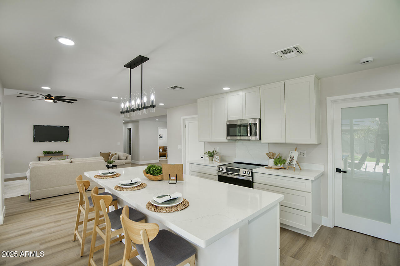 1561 North 26th Street Mesa, AZ 85213 - Photo 13 of 35 a kitchen with a sink a stove and chairs