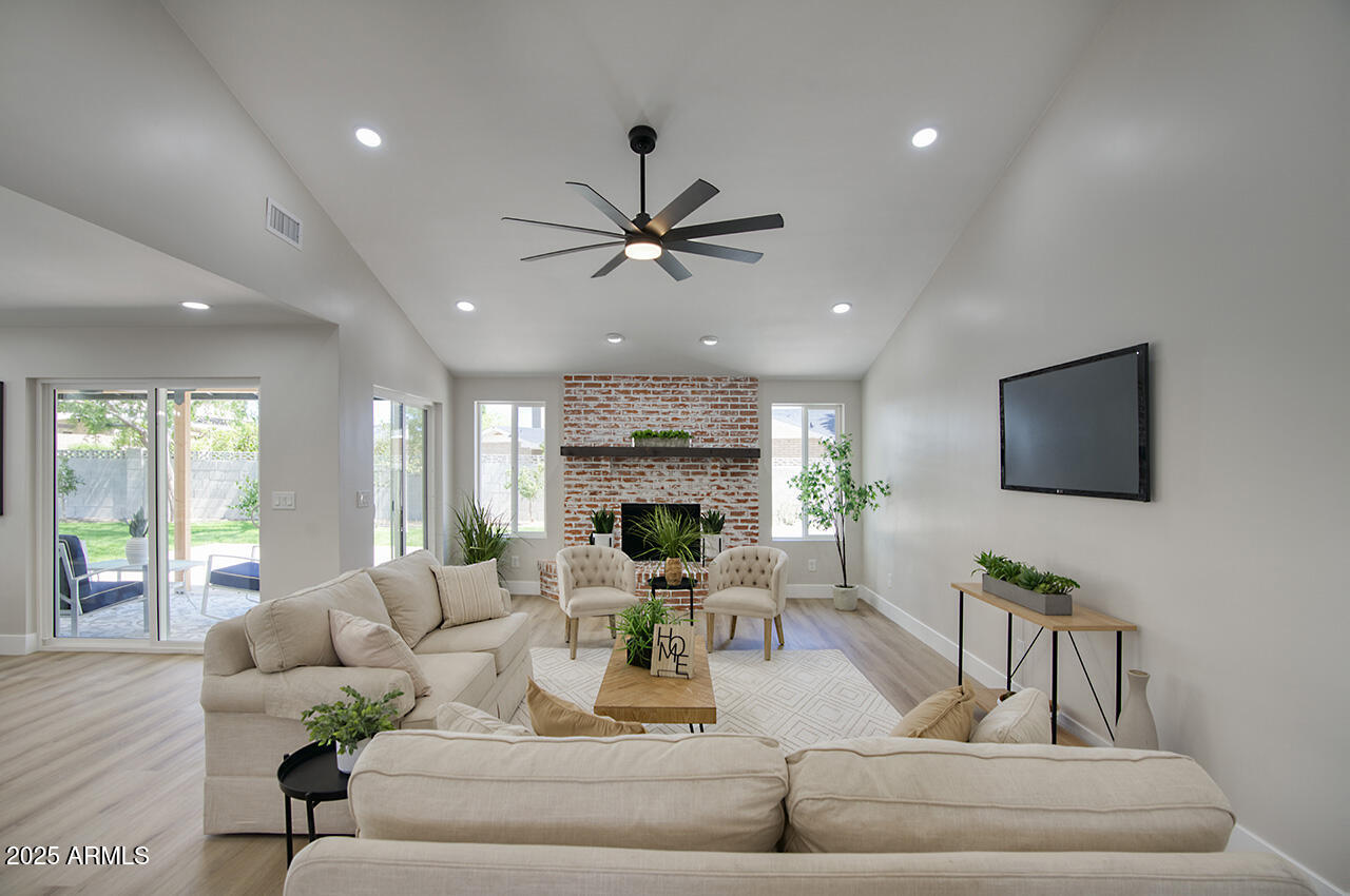 1561 North 26th Street Mesa, AZ 85213 - Photo 4 of 35 a living room with furniture a fireplace and a flat screen tv