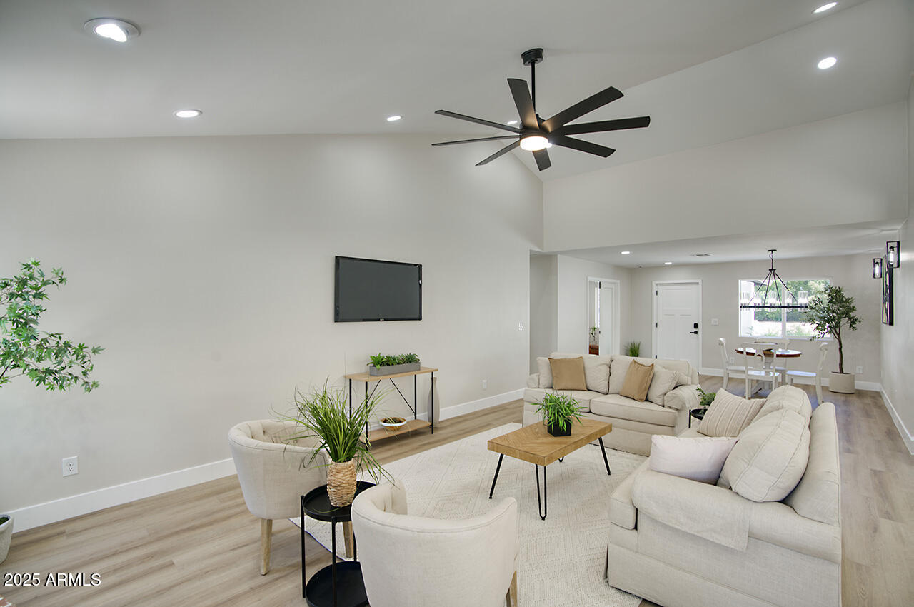 1561 North 26th Street Mesa, AZ 85213 - Photo 10 of 35 a living room with furniture a chandelier and a potted plant