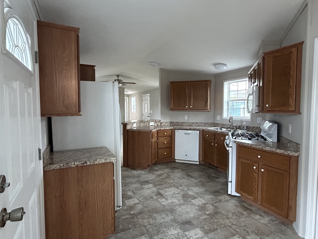 8 Alfred Street Wareham, MA 02538 - Photo 2 of 8 a kitchen with a refrigerator sink and wooden cabinets