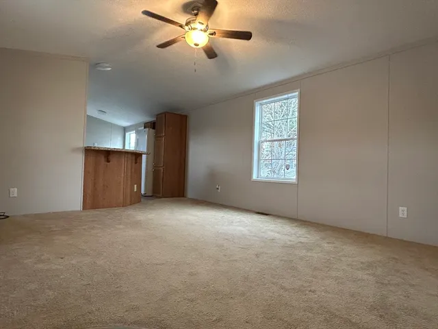an empty room with windows and fan