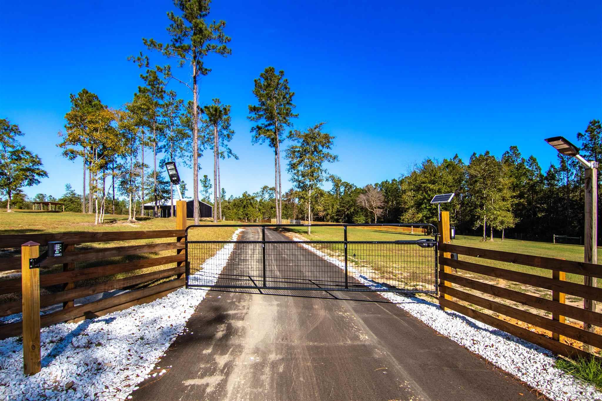 2232 Bison Drive Pace, FL 32571 - Photo 1 of 27 a view of a swimming pool with a bench and trees around