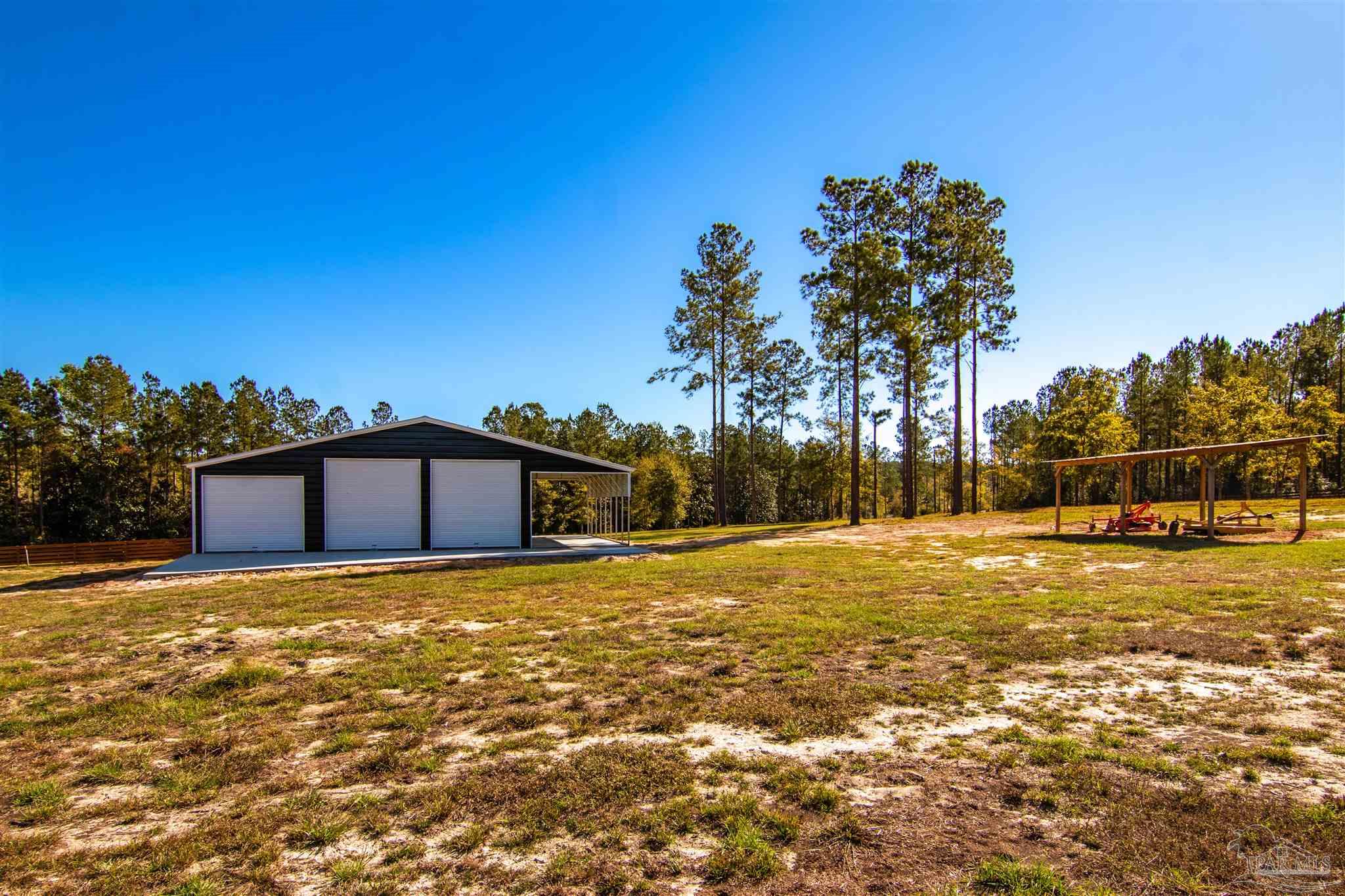 2232 Bison Drive Pace, FL 32571 - Photo 14 of 27 a view of a large house with a yard and trees in the background