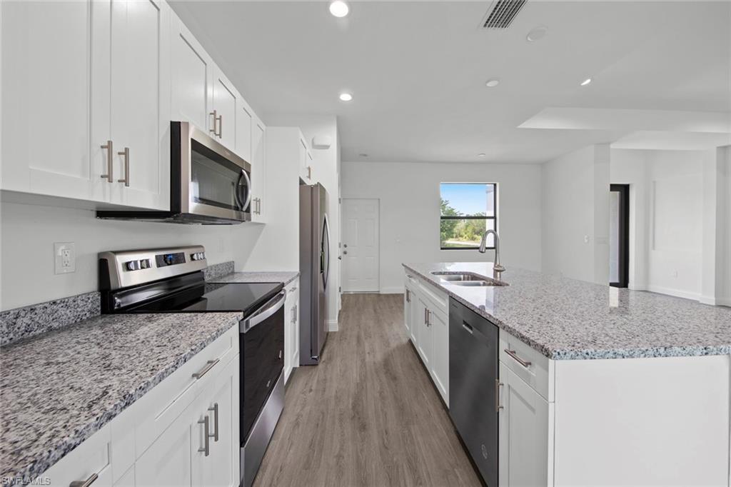 355 Ranier Avenue Lehigh Acres, FL 33974 - Photo 15 of 27 a kitchen with stainless steel appliances granite countertop a sink stove and refrigerator
