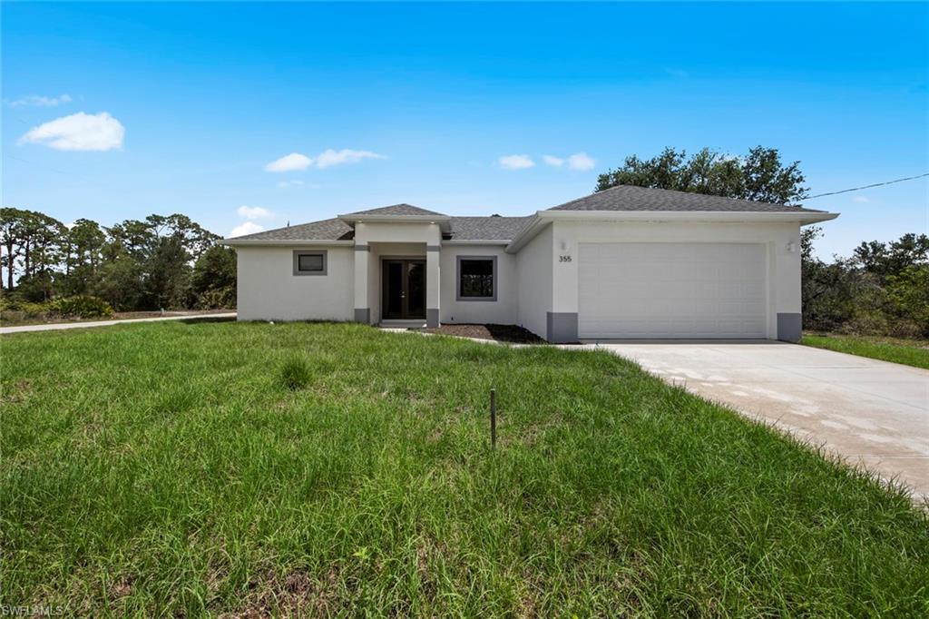 355 Ranier Avenue Lehigh Acres, FL 33974 - Photo 2 of 27 a view of a house with a yard