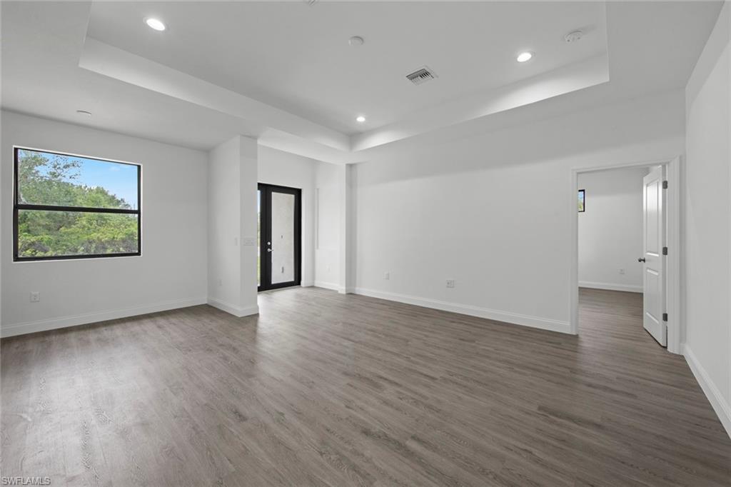 355 Ranier Avenue Lehigh Acres, FL 33974 - Photo 10 of 27 an empty room with wooden floor and windows