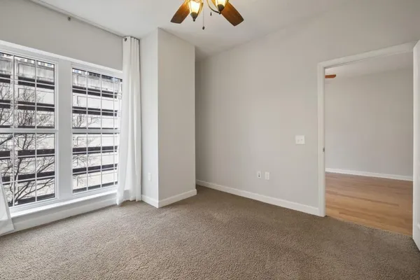 an empty room with fan and entrance