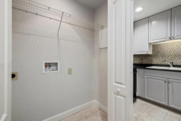 a kitchen with granite countertop white cabinets and black appliances