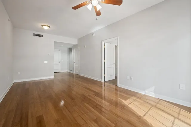 a dining room with wooden floor a chandelier a wooden table and chairs