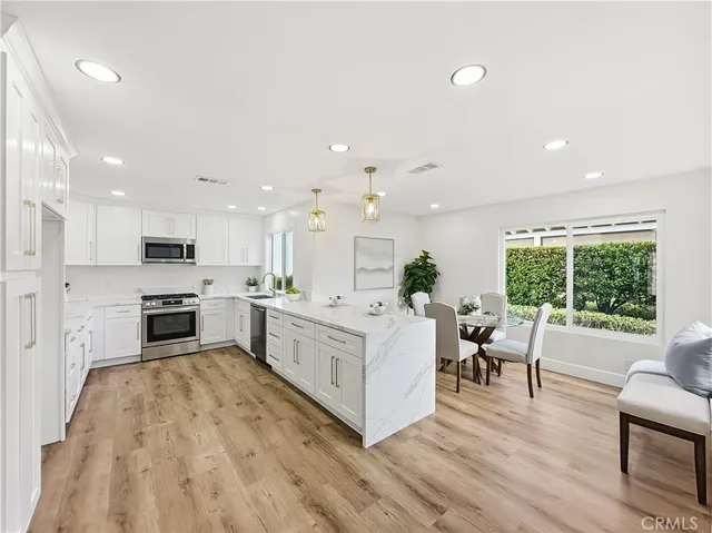 a large white kitchen with stainless steel appliances