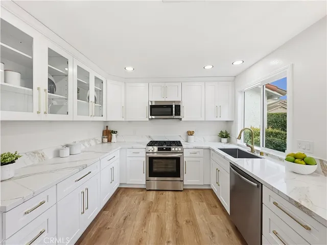 a kitchen with a sink stove cabinets and window