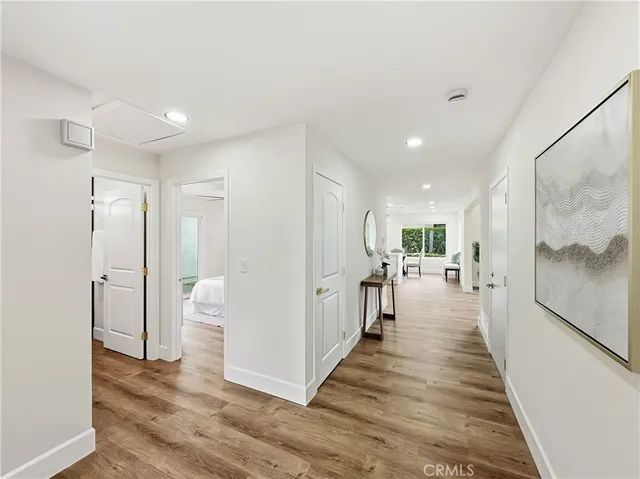 a view of a hallway with the wooden floor and a living room