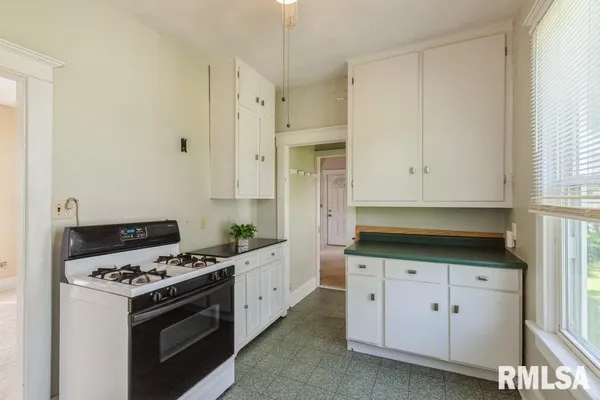 a kitchen with granite countertop a stove a sink and a refrigerator