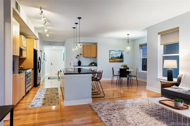 a large kitchen with kitchen island a dining table chairs and a rug