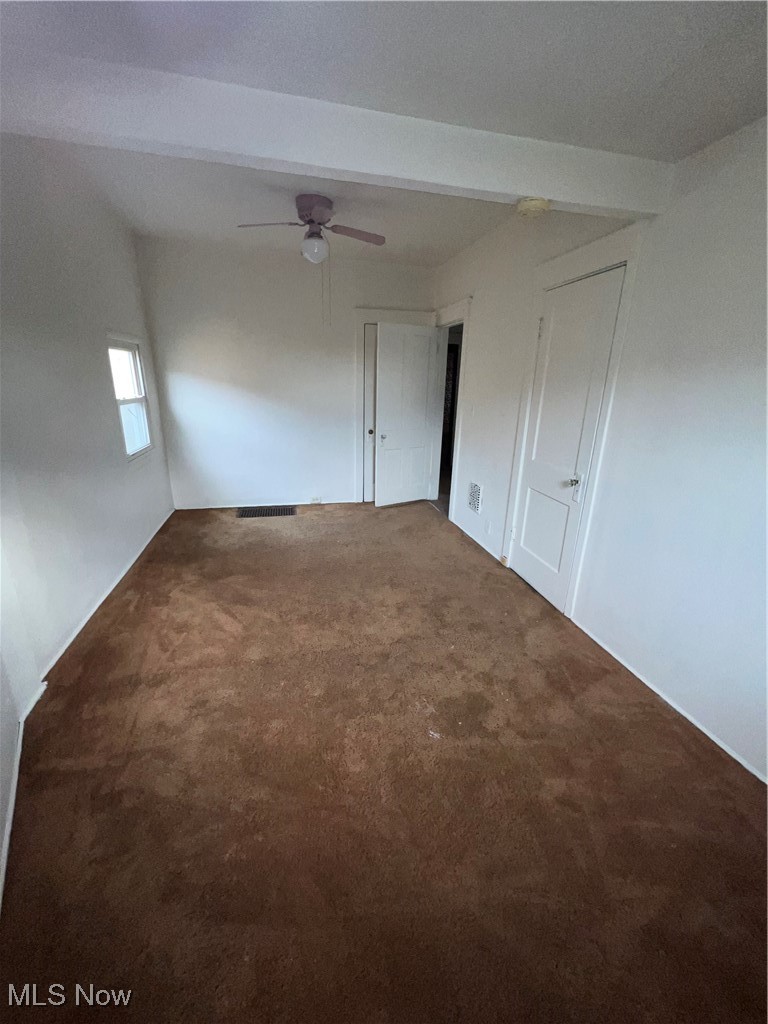 1334 Penhurst Road Cleveland, OH 44110 - Photo 20 of 20 Empty room with carpet, beam ceiling, and a ceiling fan