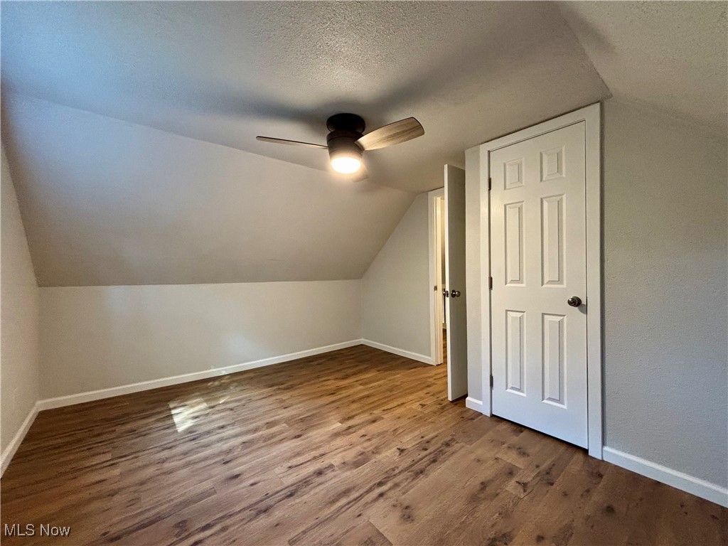 3522 Tent Church Road Colliers, WV 26035 - Photo 13 of 27 Additional living space with dark wood-style floors, a textured ceiling, vaulted ceiling, and a ceiling fan