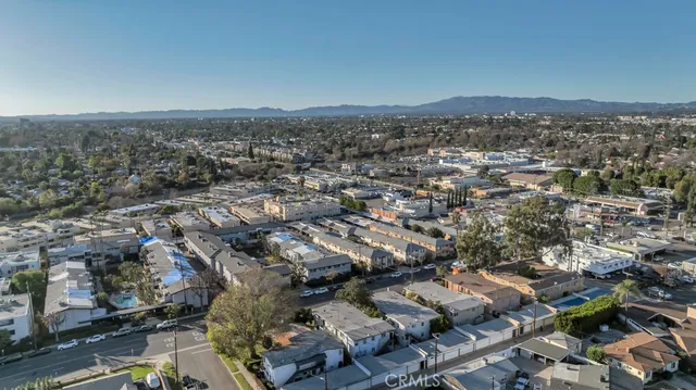 an aerial view of residential houses with outdoor space and trees