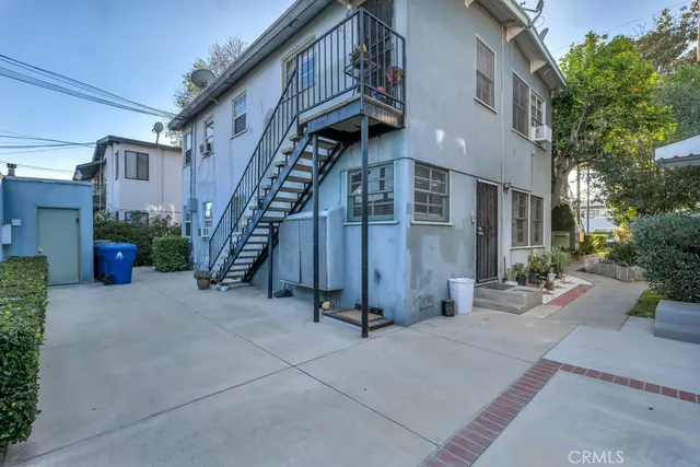 a view of a building with potted plants and a pathway