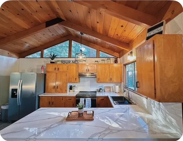 a kitchen with stainless steel appliances wooden cabinets a sink and a dishwasher