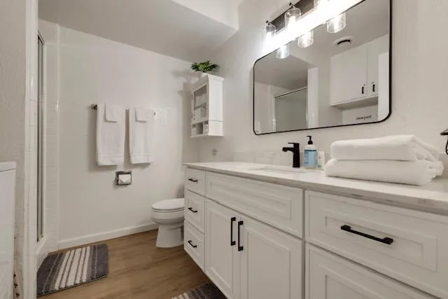 a bathroom with a double vanity sink mirror and toilet