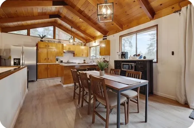 a dining table with chairs and kitchen view
