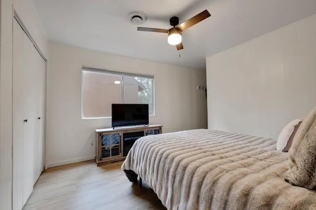 a bedroom with a bed and a flat tv screen on wall
