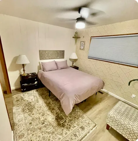 a bedroom with a bed and a lamp on the dresser